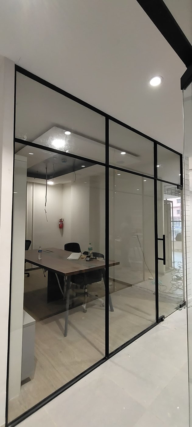 Slim black-framed glass partition with door