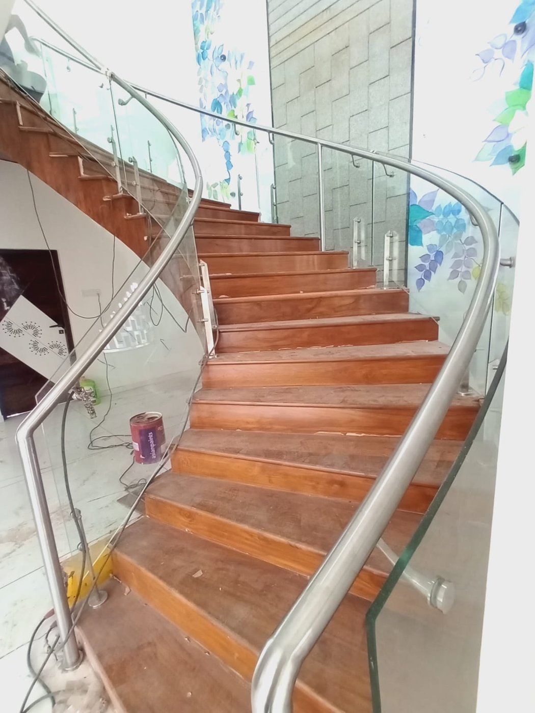 Curved glass staircase railing with steel handrail